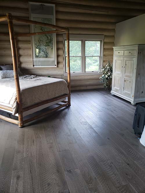 Log cabin home interior with Pekoe hardwood floors in a bedroom